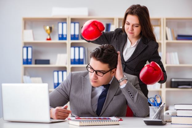 woman wearing boxing gloves behind a man